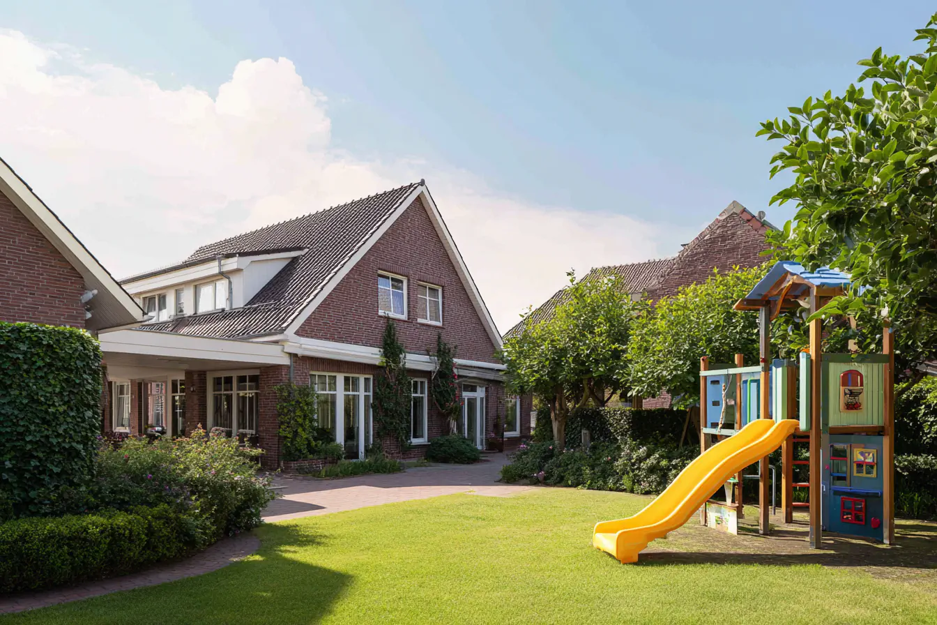 Ziegelhaus mit Spielplatz und gelber Rutsche im Garten.